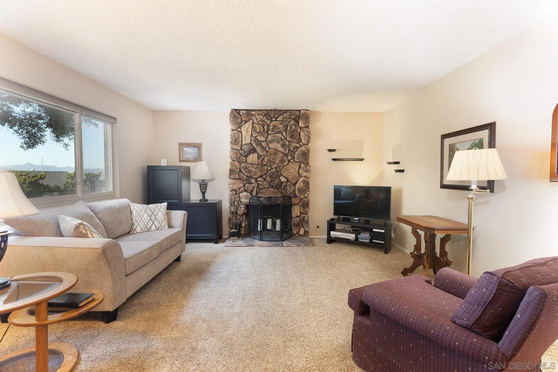 12455 Ridgeton Drive Lakeside, CA 92040 - Photo 4 of 31 a living room with furniture a fireplace and a flat screen tv