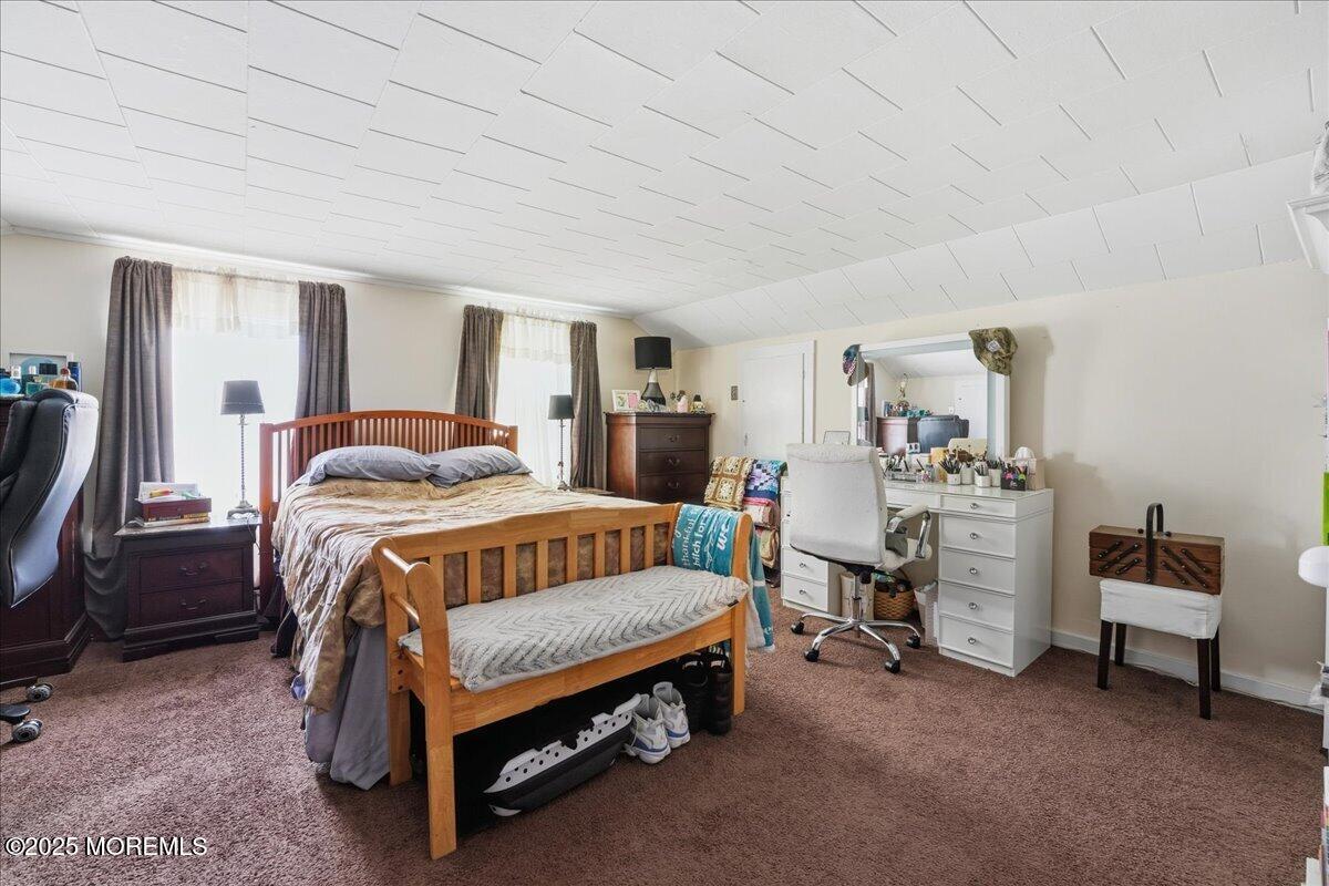 233 Broadway Union Beach, NJ 07735 - Photo 27 of 45 a bedroom with a bed and a chandelier