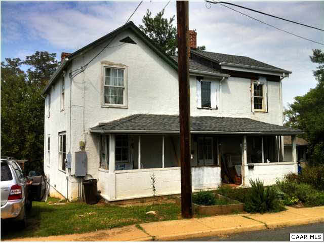 881 Ridge Street Charlottesville, VA 22902 - Photo 1 of 16 a view of a white house with a large windows and a yard with plants and large trees