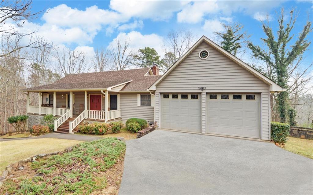 a view of a house with a yard and large tree
