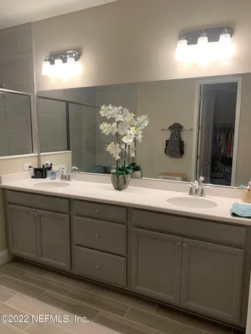 a bathroom with a double vanity sink and a mirror