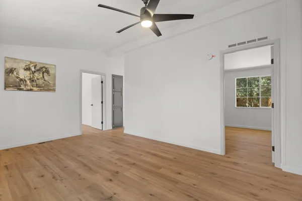 an empty room with wooden floor and windows