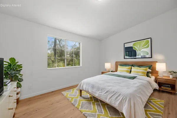 a bedroom with a bed lamp and a potted plant