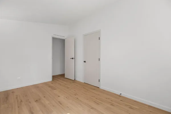 a view of empty room with wooden floor