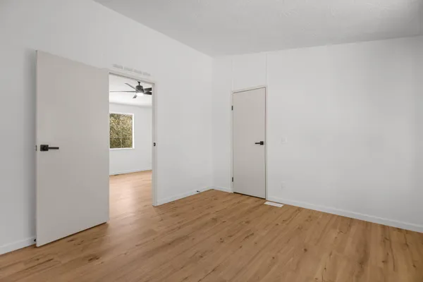 a view of an empty room with wooden floor
