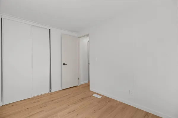 a view of a big room with wooden floor and windows