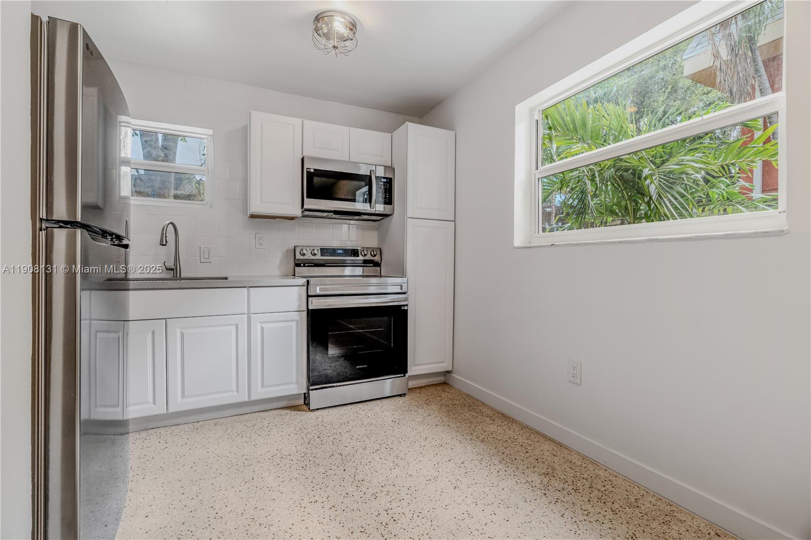 421 Southwest 9th Street, Unit 3 Miami, FL 33130 - Photo 6 of 10 a kitchen with stainless steel appliances granite countertop a stove a sink and a microwave