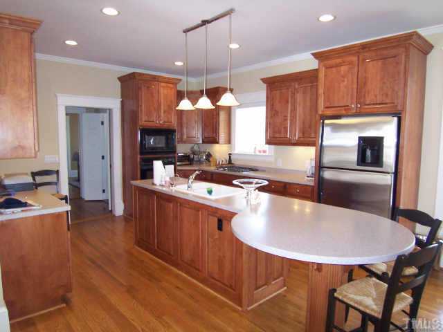 1708 Dare Street Raleigh, NC 27608 - Photo 4 of 9 a kitchen with kitchen island a dining table chairs sink and microwave