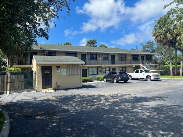 a front view of a house with cars parked