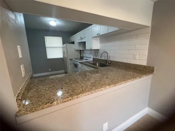 a kitchen with kitchen island sink granite counter tops and a counter top space