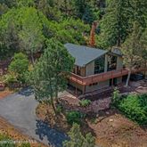 an aerial view of a house with a yard and large trees