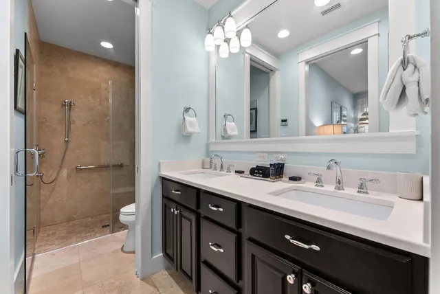 a bathroom with a granite countertop sink a toilet and shower