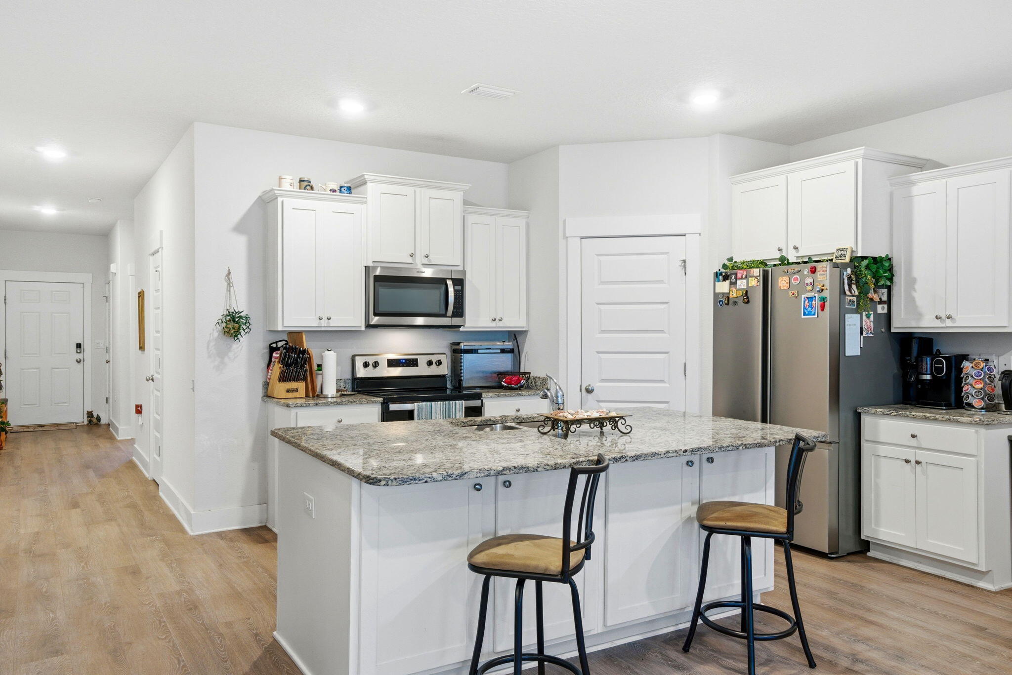 4067 Blaney Lane Pace, FL 32571 - Photo 6 of 40 a kitchen with stainless steel appliances granite countertop a stove top oven a refrigerator a sink and white cabinets with wooden floor