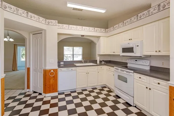 a kitchen with granite countertop appliances cabinets and a sink