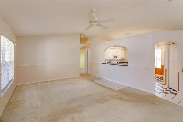 an empty room with a window and a ceiling fan