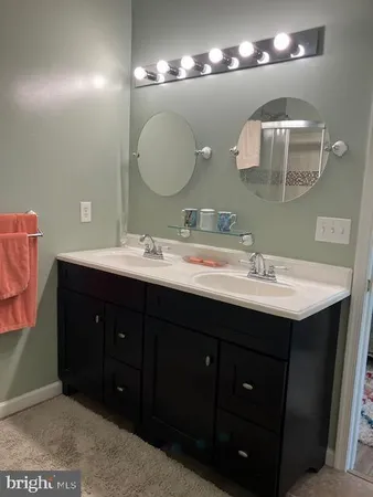 a bathroom with a sink vanity and a mirror