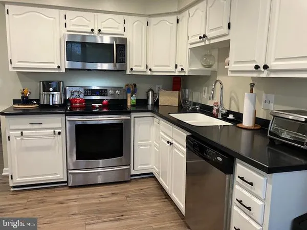 a kitchen with stainless steel appliances granite countertop a sink a stove and a microwave