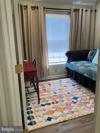 a view of empty room with window and wooden floor
