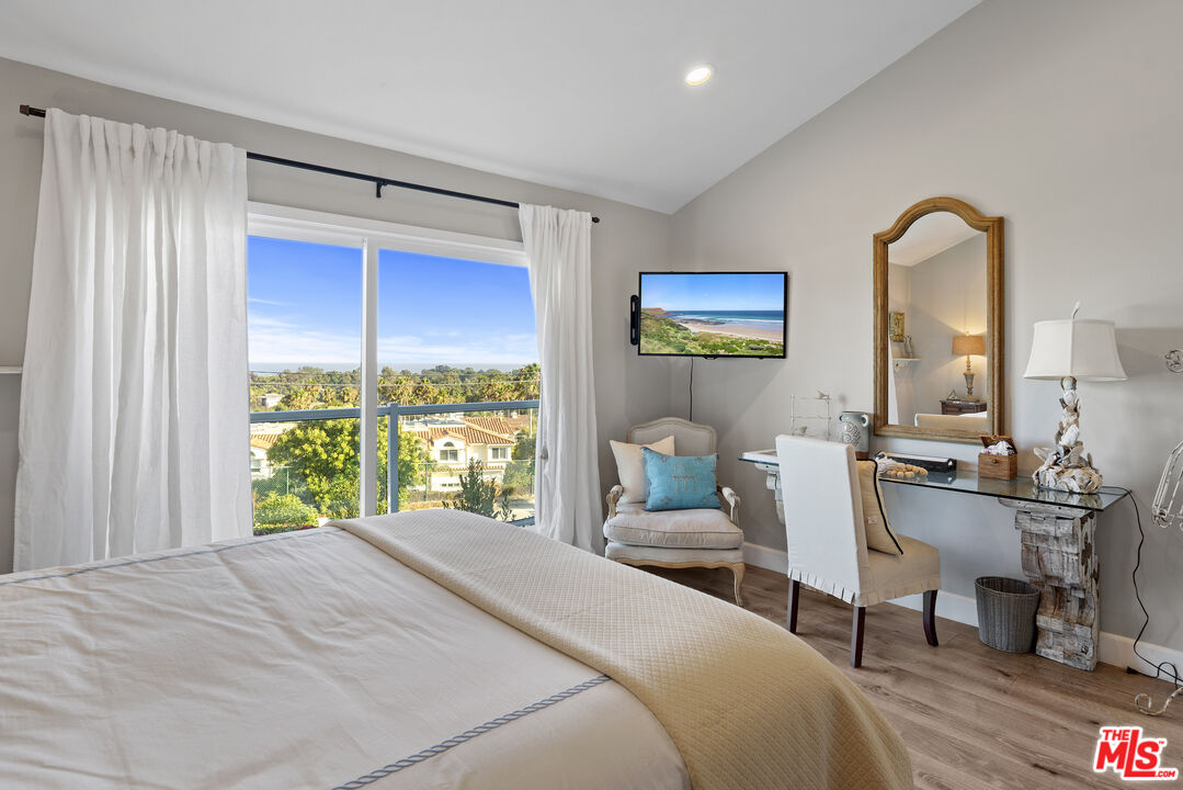 6363 Zumirez Drive Malibu, CA 90265 - Photo 19 of 34 a bedroom with a large bed and a large window