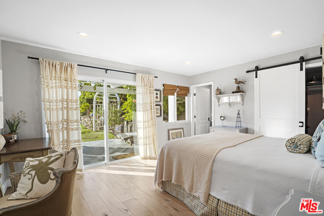 6363 Zumirez Drive Malibu, CA 90265 - Photo 23 of 34 a bedroom with a bed and a large window