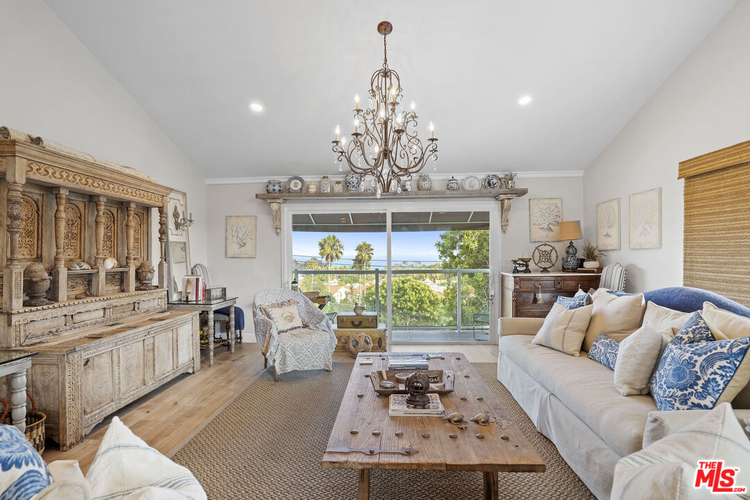 6363 Zumirez Drive Malibu, CA 90265 - Photo 6 of 34 a living room with furniture a chandelier and a chandelier