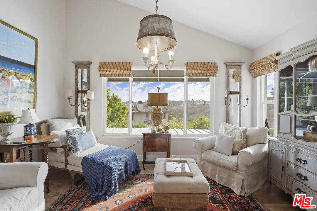 6363 Zumirez Drive Malibu, CA 90265 - Photo 8 of 34 a living room with furniture chandelier and a large window