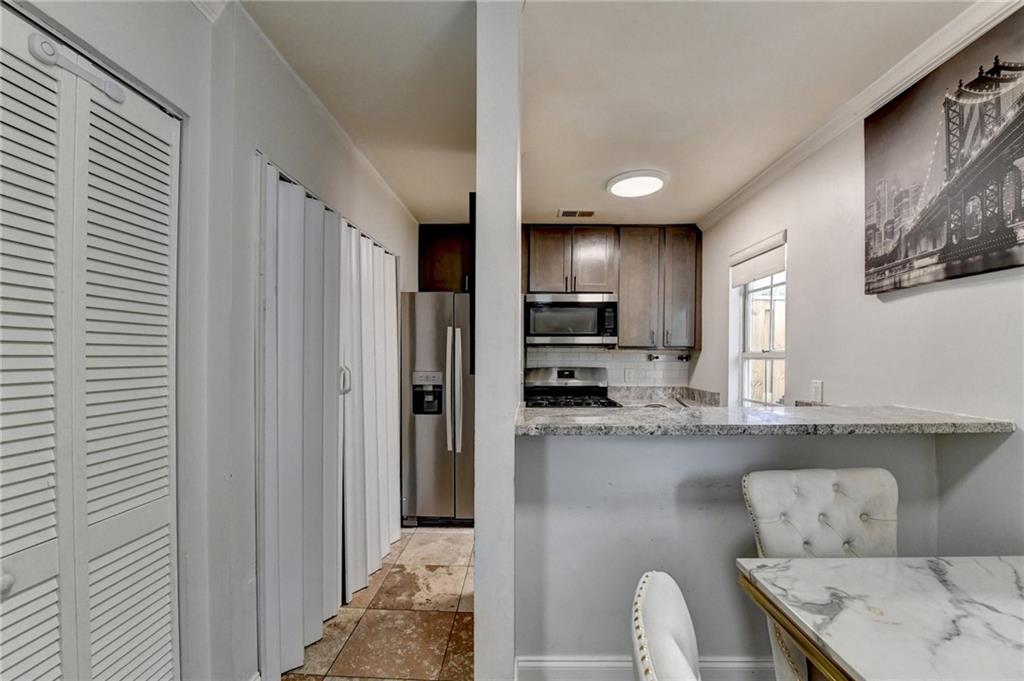 3400 Spring Harbor Drive Doraville, GA 30340 - Photo 15 of 33 a kitchen with stainless steel appliances granite countertop a refrigerator a sink dishwasher a stove and a dining table with wooden floor