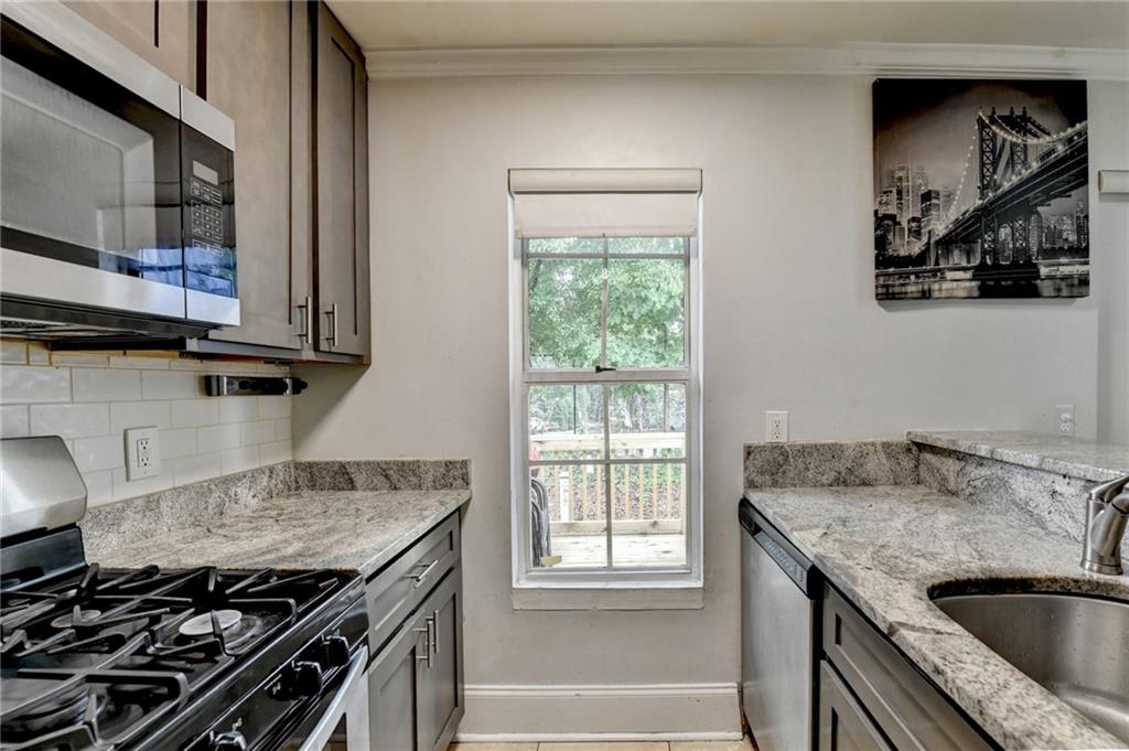 3400 Spring Harbor Drive Doraville, GA 30340 - Photo 17 of 33 a kitchen with granite countertop a stove and a sink