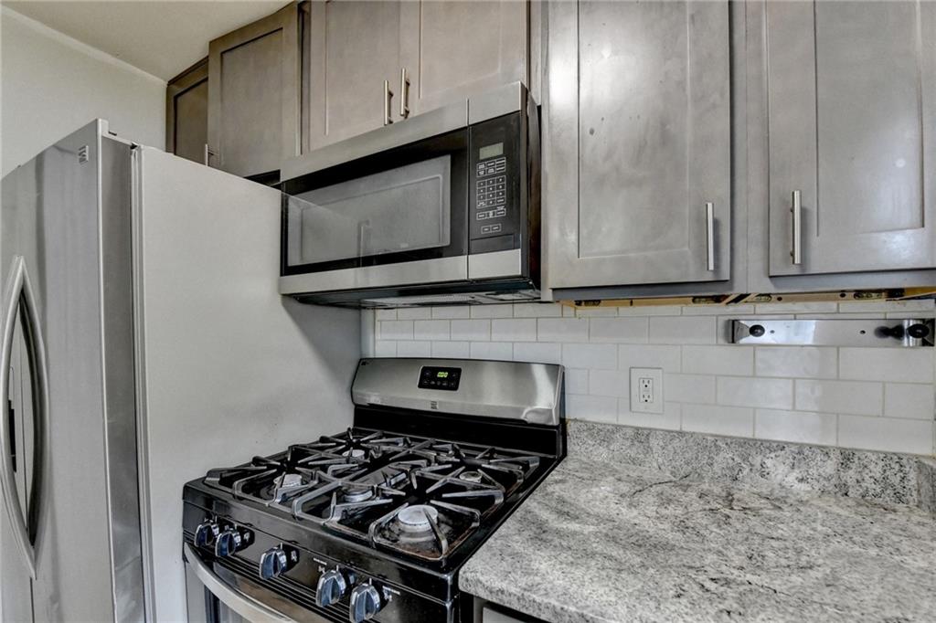 3400 Spring Harbor Drive Doraville, GA 30340 - Photo 19 of 33 a kitchen with granite countertop a stove and a microwave