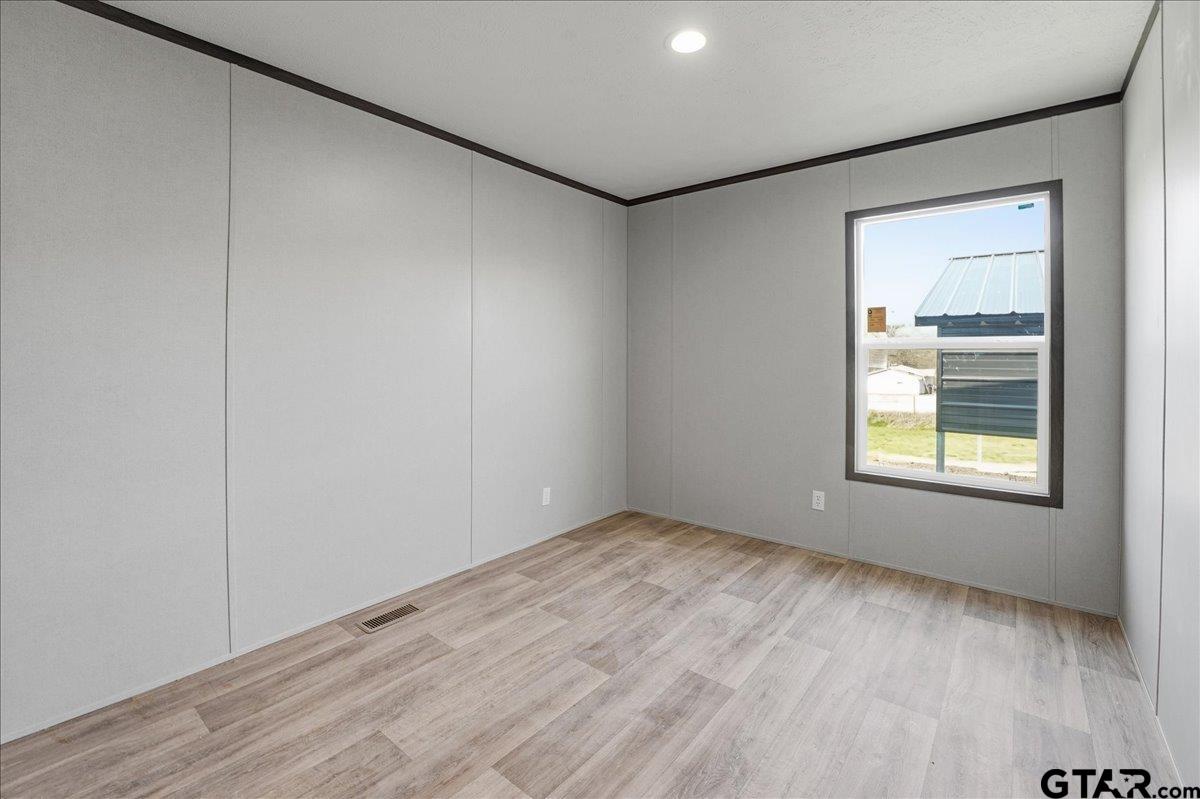 8886 Bayberry Road Gilmer, TX 75645 - Photo 12 of 24 a view of an empty room with wooden floor and a window