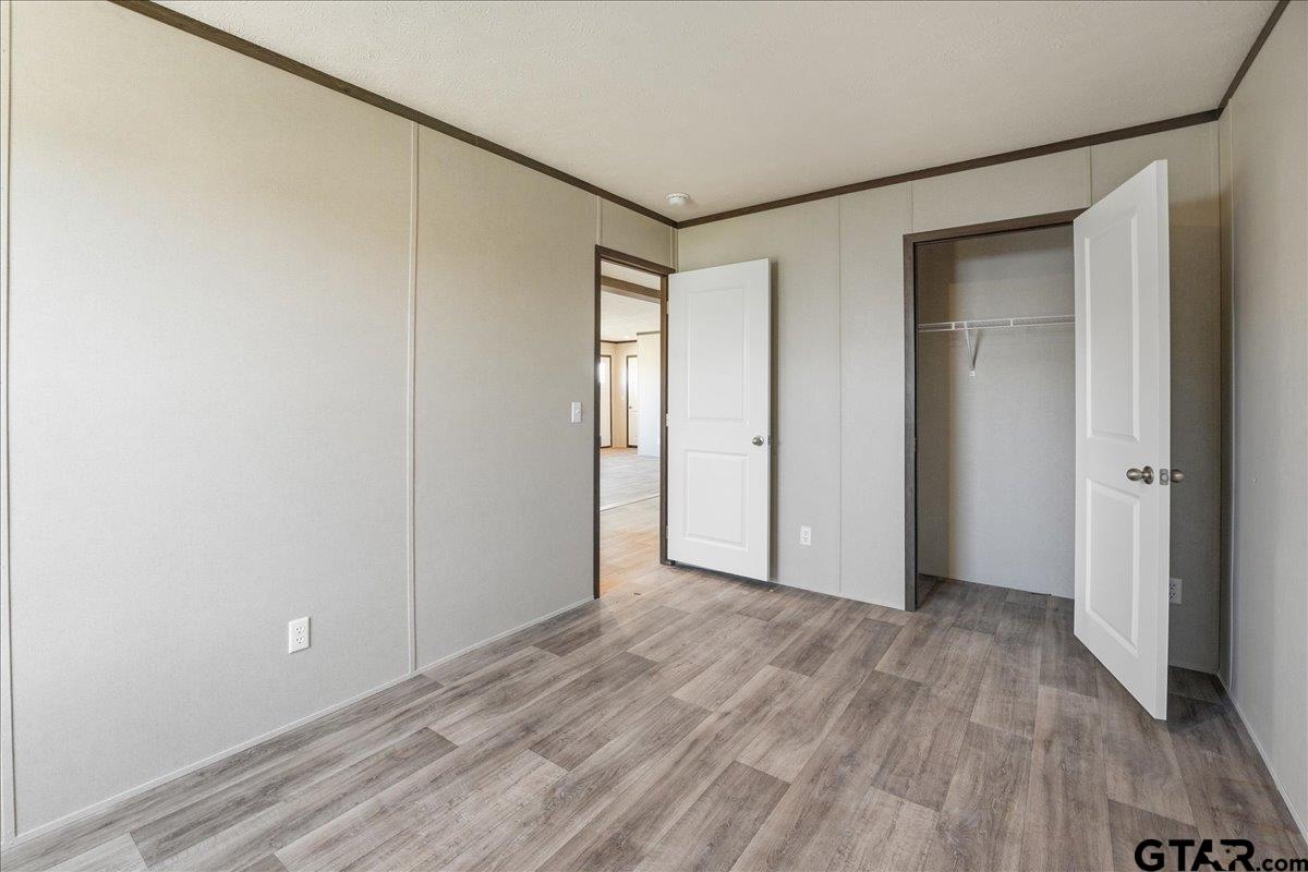 8886 Bayberry Road Gilmer, TX 75645 - Photo 13 of 24 a view of an empty room with wooden floor