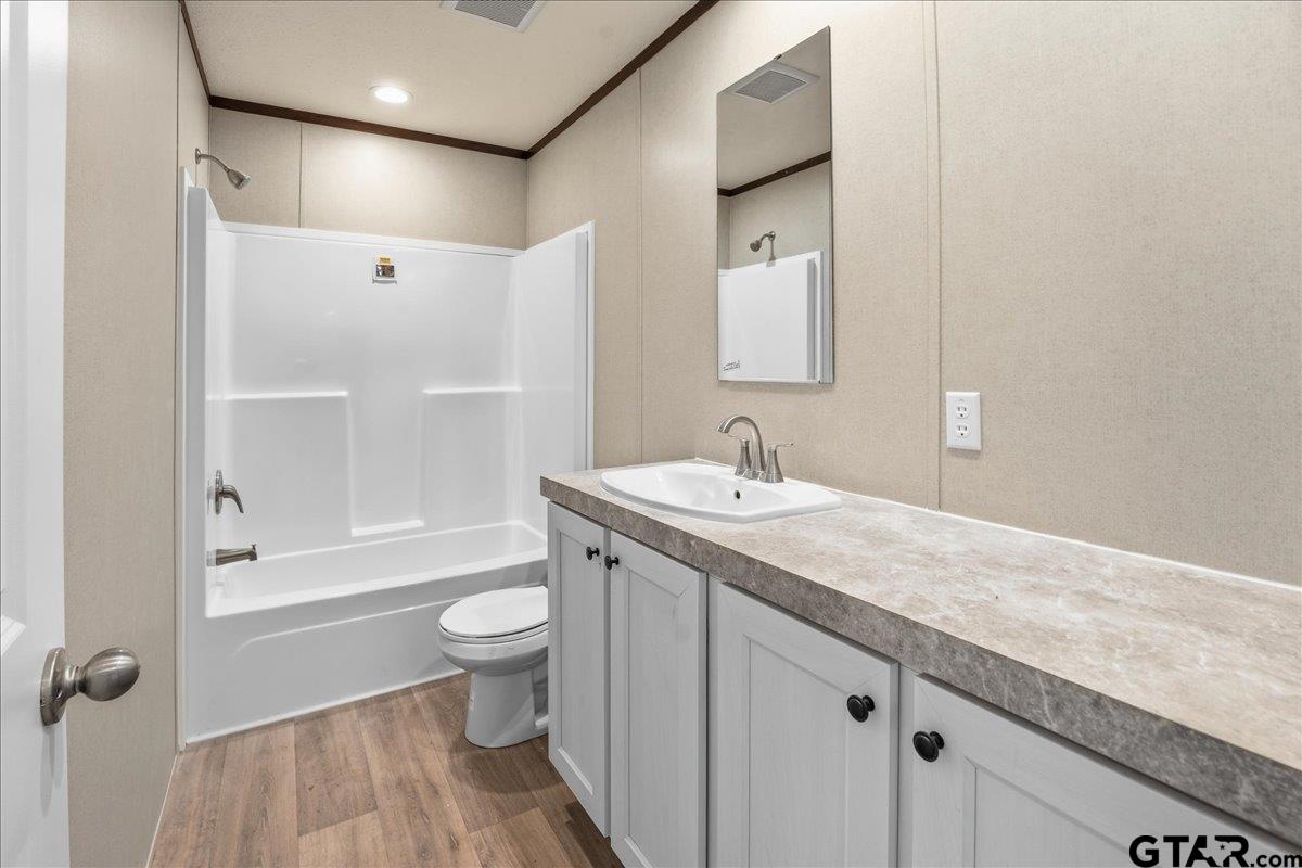 8886 Bayberry Road Gilmer, TX 75645 - Photo 14 of 24 a bathroom with a granite countertop sink a toilet and shower