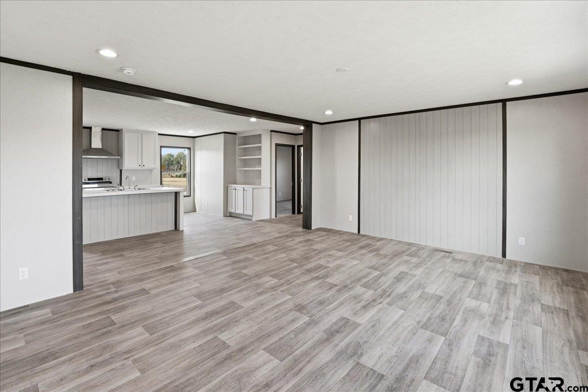 8886 Bayberry Road Gilmer, TX 75645 - Photo 17 of 24 a view of a big room with wooden floor and windows