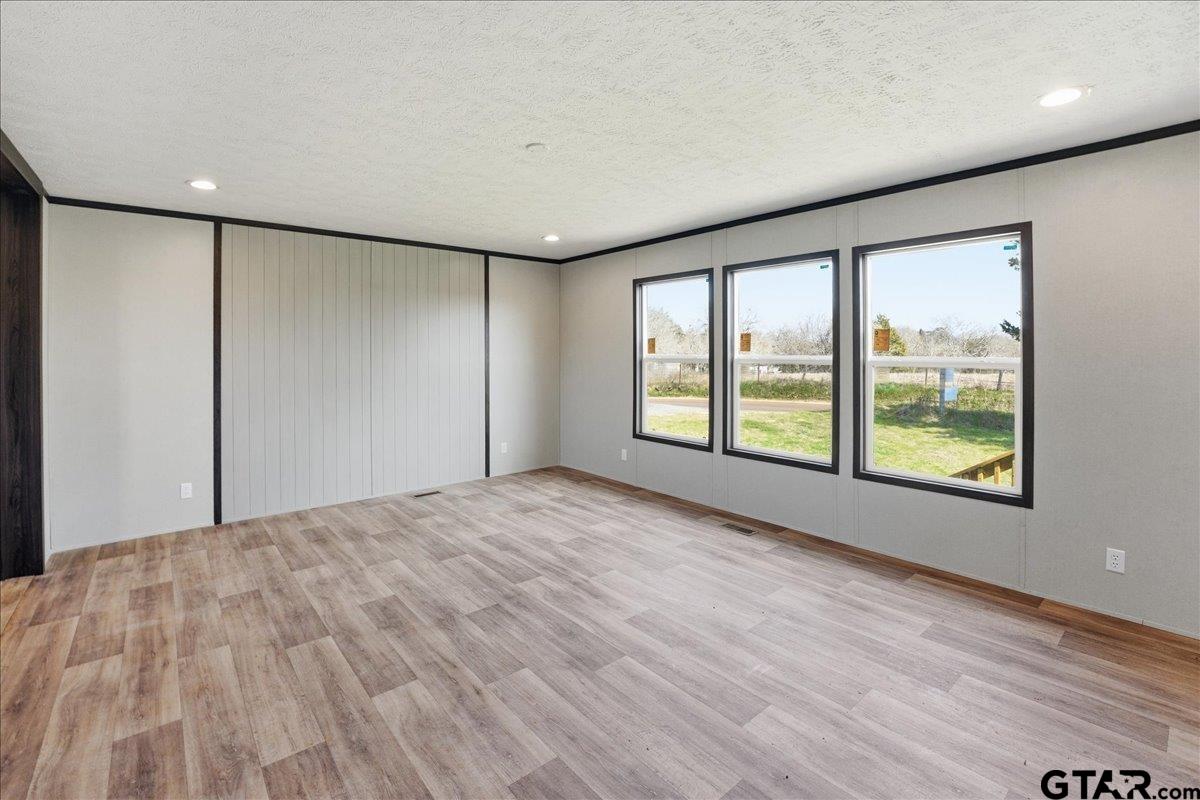 8886 Bayberry Road Gilmer, TX 75645 - Photo 19 of 24 a view of an empty room with a window and wooden floor