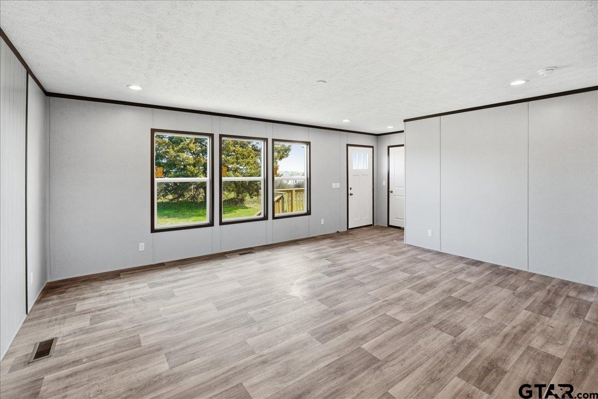 8886 Bayberry Road Gilmer, TX 75645 - Photo 20 of 24 a view of an empty room with a window and wooden floor