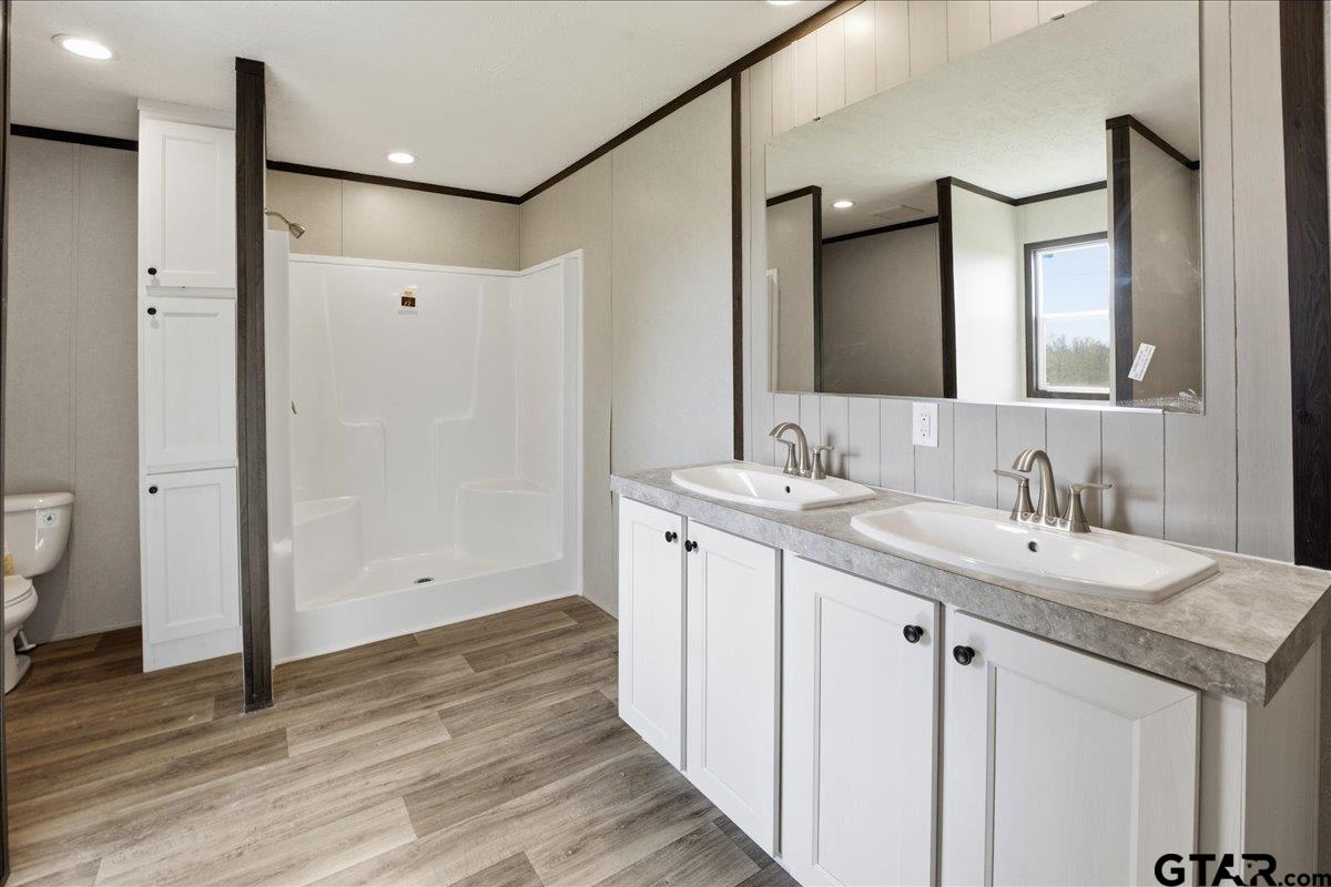 8886 Bayberry Road Gilmer, TX 75645 - Photo 6 of 24 a bathroom with a granite countertop sink a toilet and a mirror
