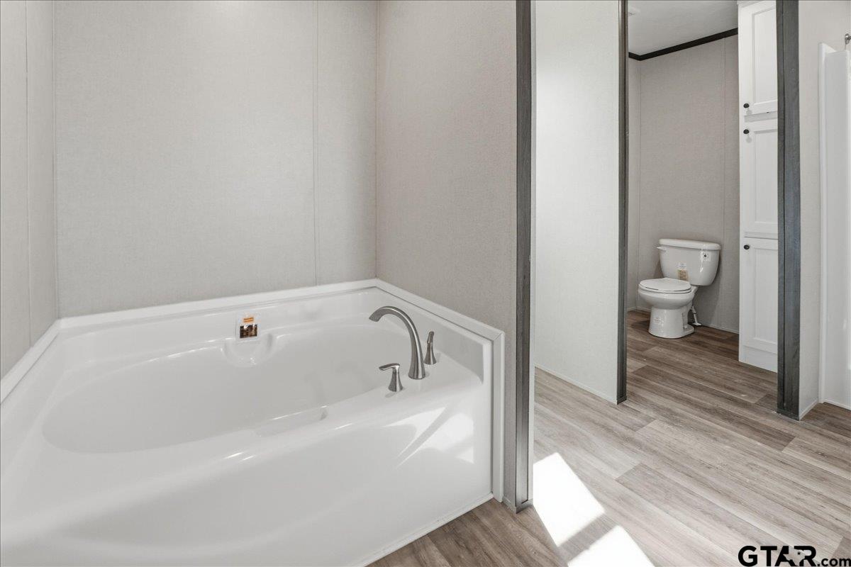 8886 Bayberry Road Gilmer, TX 75645 - Photo 8 of 24 a bathroom with a bathtub and a toilet