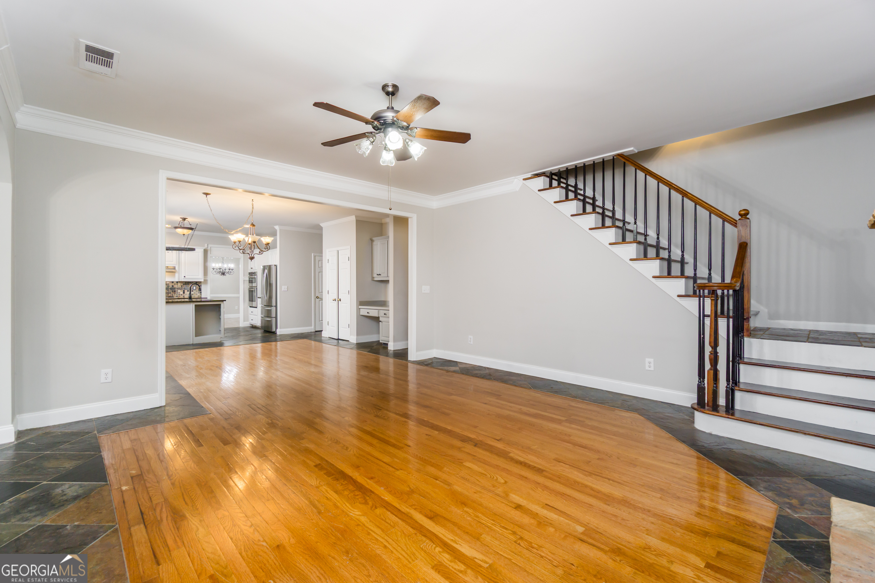 6710 Timber Cove Pointe Cumming, GA 30041 - Photo 21 of 51 a view of an empty room with wooden floor and a kitchen