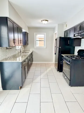 a kitchen with stainless steel appliances granite countertop a stove a sink and a microwave