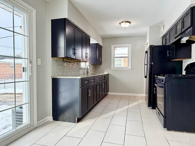 a kitchen with stainless steel appliances granite countertop a refrigerator and a stove top oven