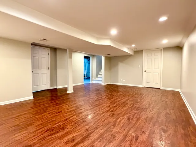 a view of an empty room with wooden floor