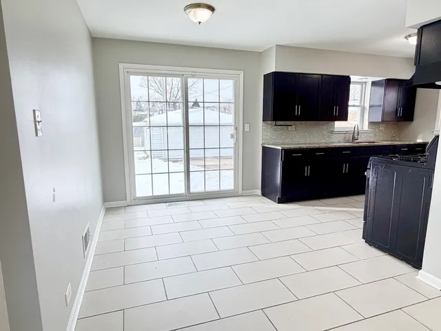 a large kitchen with a sink a microwave and cabinets