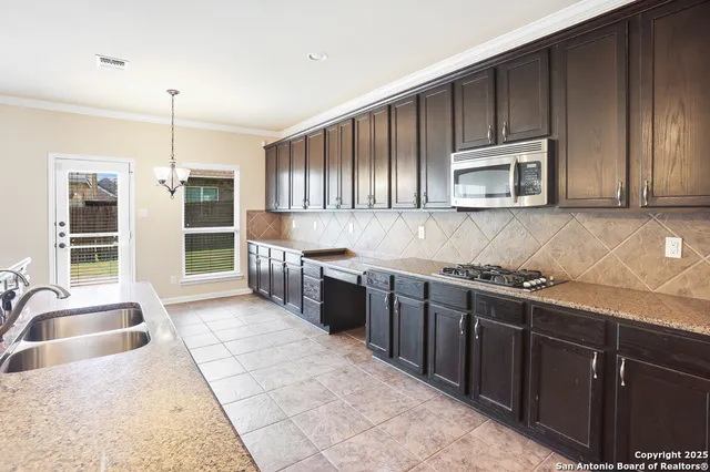 a kitchen with stainless steel appliances kitchen island granite countertop a sink stove and cabinets