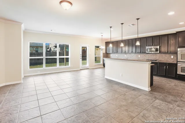 a kitchen with stainless steel appliances granite countertop a stove a sink and a granite counter tops