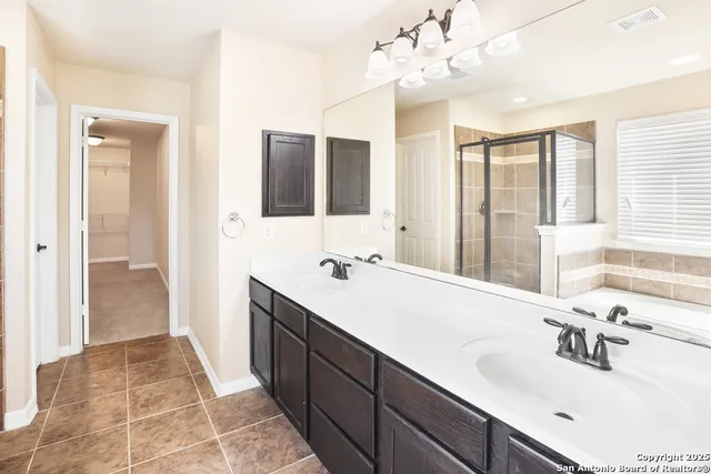 a bathroom with a tub a sink and a large mirror