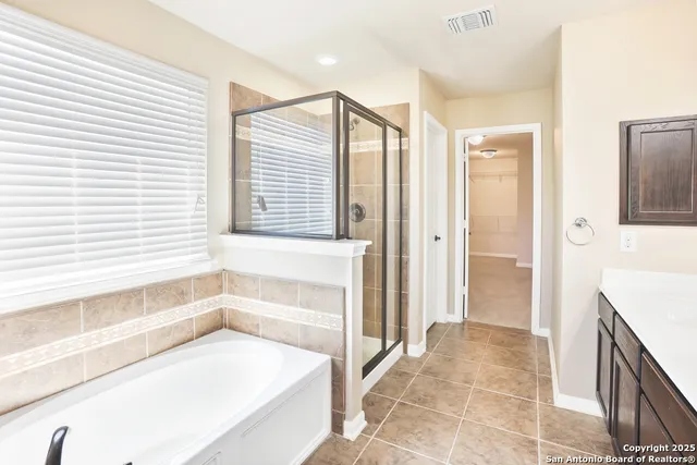 a view of a white house with a small yard and wooden fence