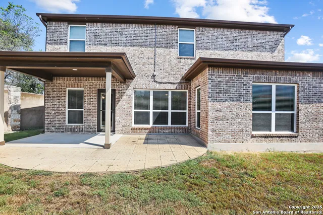 a view of a house with a small yard and wooden fence