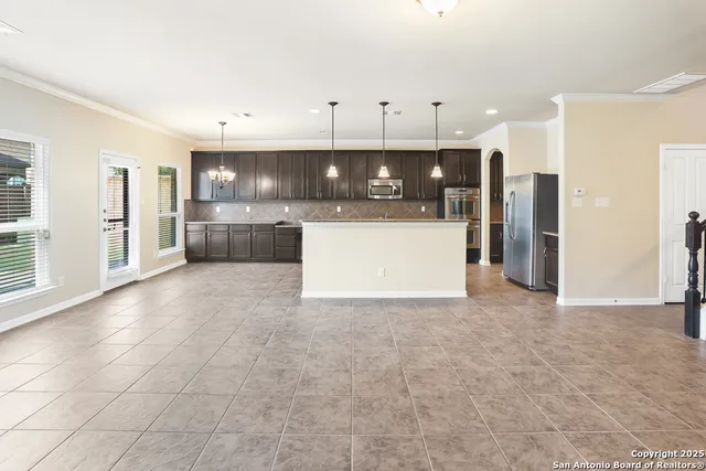 a view of kitchen with stainless steel appliances granite countertop white cabinets and refrigerator