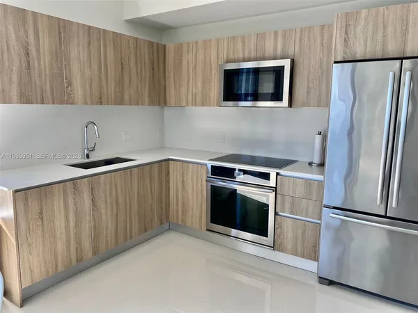 a kitchen with stainless steel appliances a stove a microwave and a refrigerator