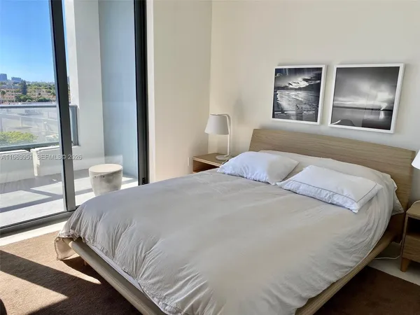 a bedroom with a large bed and a window